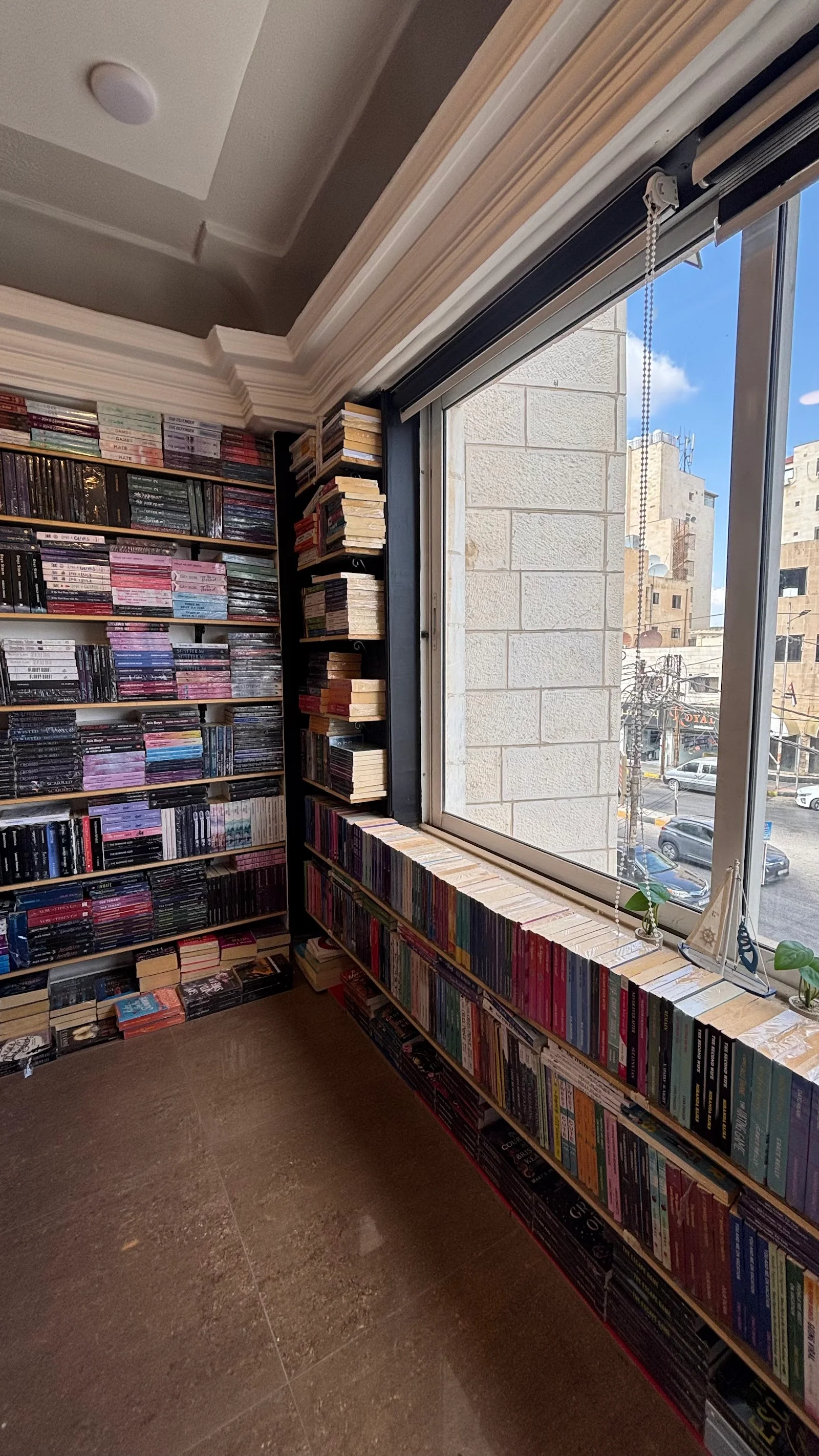 رفوف الكتب بجوار نافذة مكتبة كاف